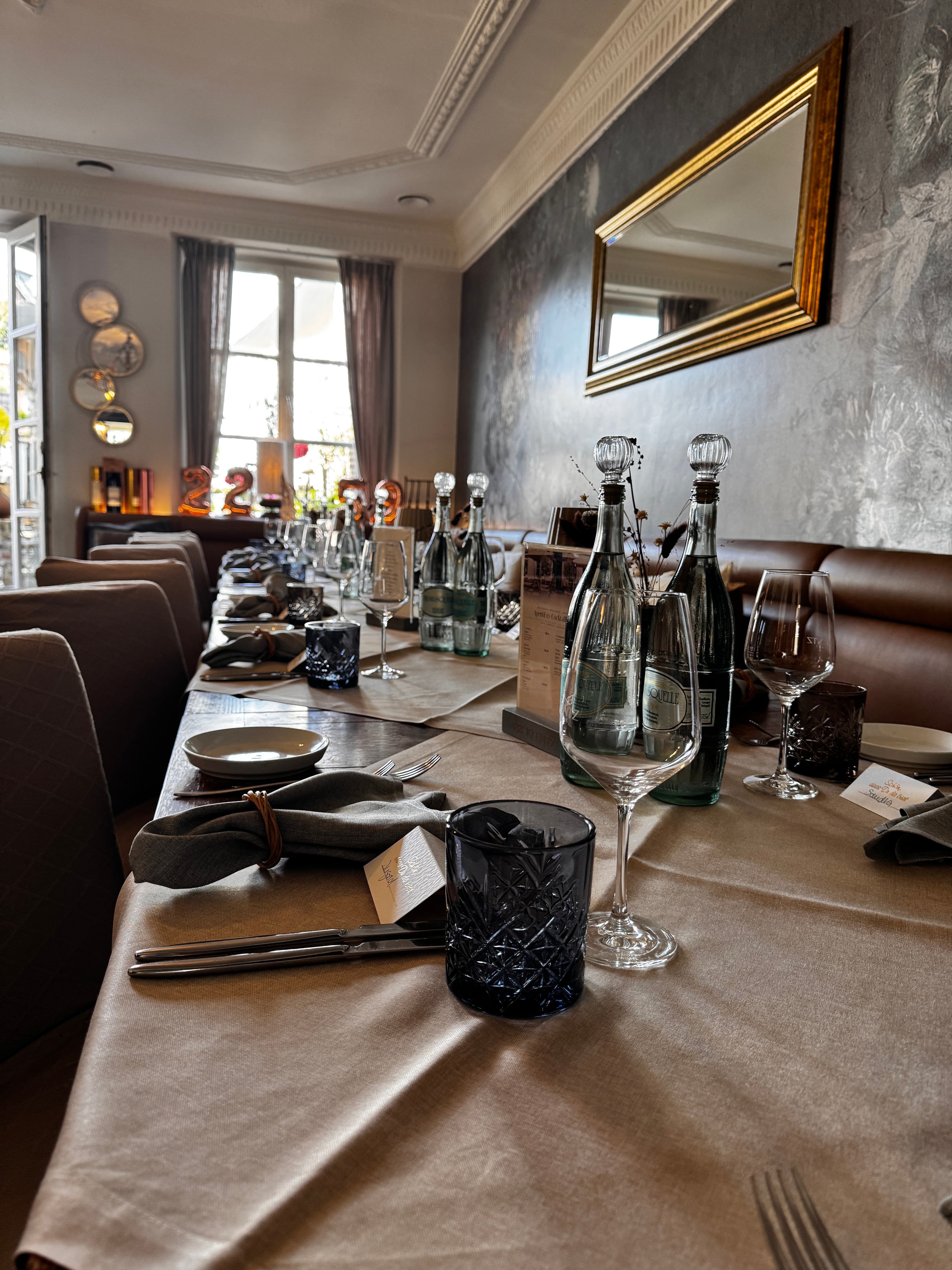 Lange Tafel im Restaurant Ercklentz mit Stoffservietten, Tellern und Gläsern eingedeckt
